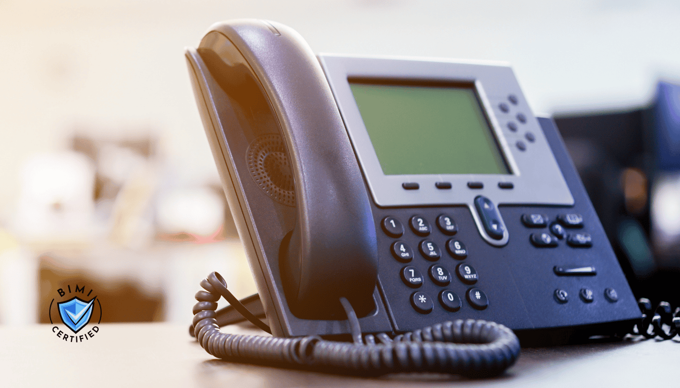 En moderne telefon på skrivebordet, der afventer et BIMI-verificeringsopkald